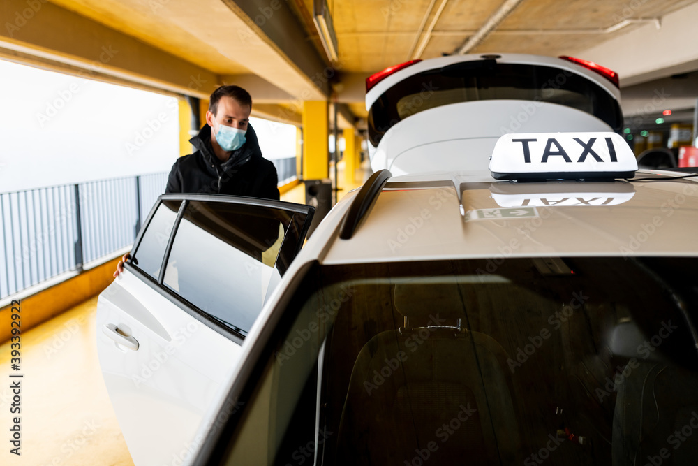 Passenger opening the door of the cab at the underground parking during coronavirus pandemic