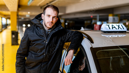 Obraz na płótnie Taxi driver posing with his car at the underground parking w salonie