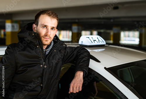 Obraz na płótnie Young taxi driver posing with his car w salonie