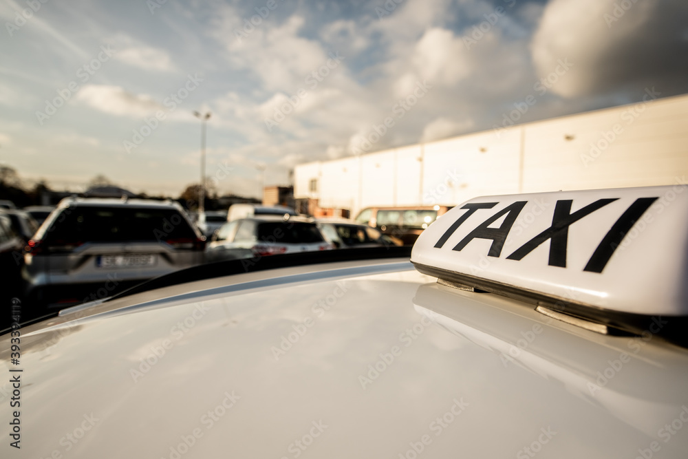Taxi sign with the view at the parking
