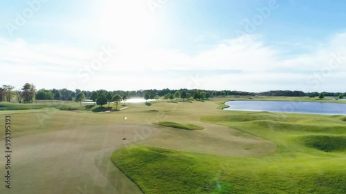 Parallax around the 18th hole green with two lakes and the sun