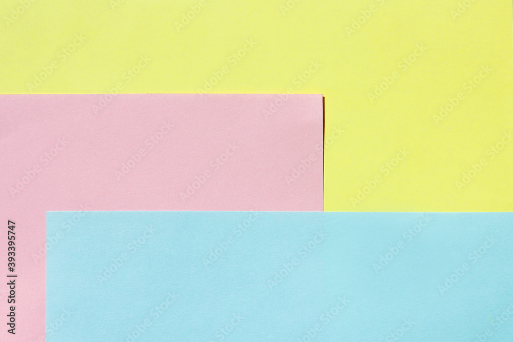 yellow, pink, and blue sheet of paper. multi-colored light background yellow, pink, and blue sheet of paper. multi-colored light background