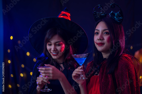 attractive Asian women enjoy party night life with wine drinking glasses in hand. Halloween festival celebration concept. 