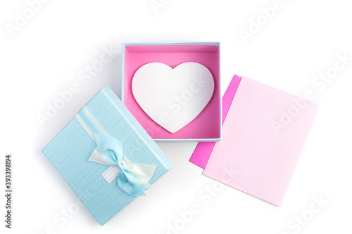 Two envelopes and a gift box with a heart on a light background. Top view with space to copy. Concept of holiday backgrounds, February 14.