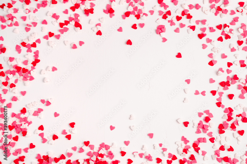 Lots of little red, pink and white hearts on a light background. Top view, with space to copy. The Concept Of Valentine's Day.