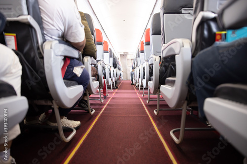 Airplane Aisle with the Passengers Sitting on their Seats