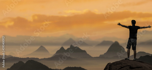 man with open arms on the Top of foggy Mountain Sunset.