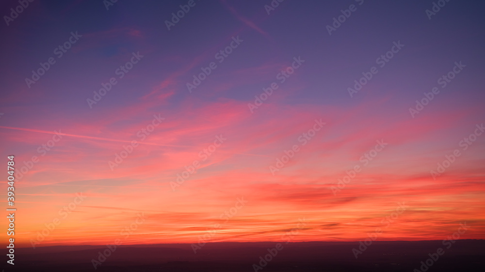 Evening colorful purple-pink sky with red clouds and orange horizon. Aerial photography, sky over the whole photo. Photo perfect for background exchange.