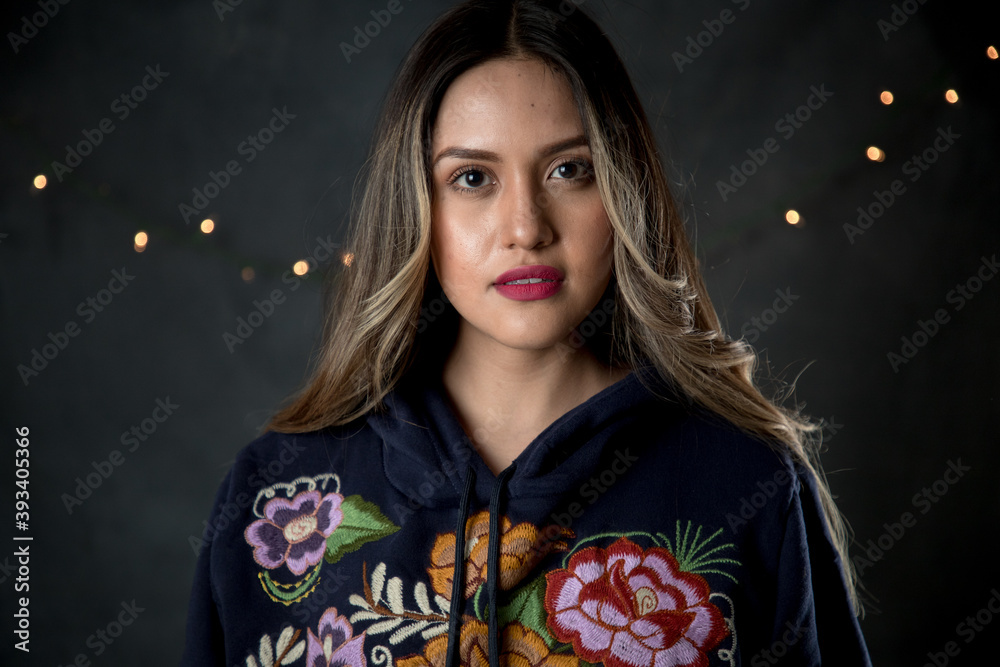 Mujer latina abrigada con sudadera floreada. Mujer latina abrigada con sudadera floreada.