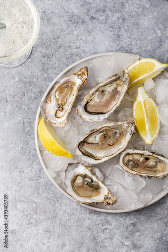 Fresh raw oysters on ice with lemon and glass of champagne