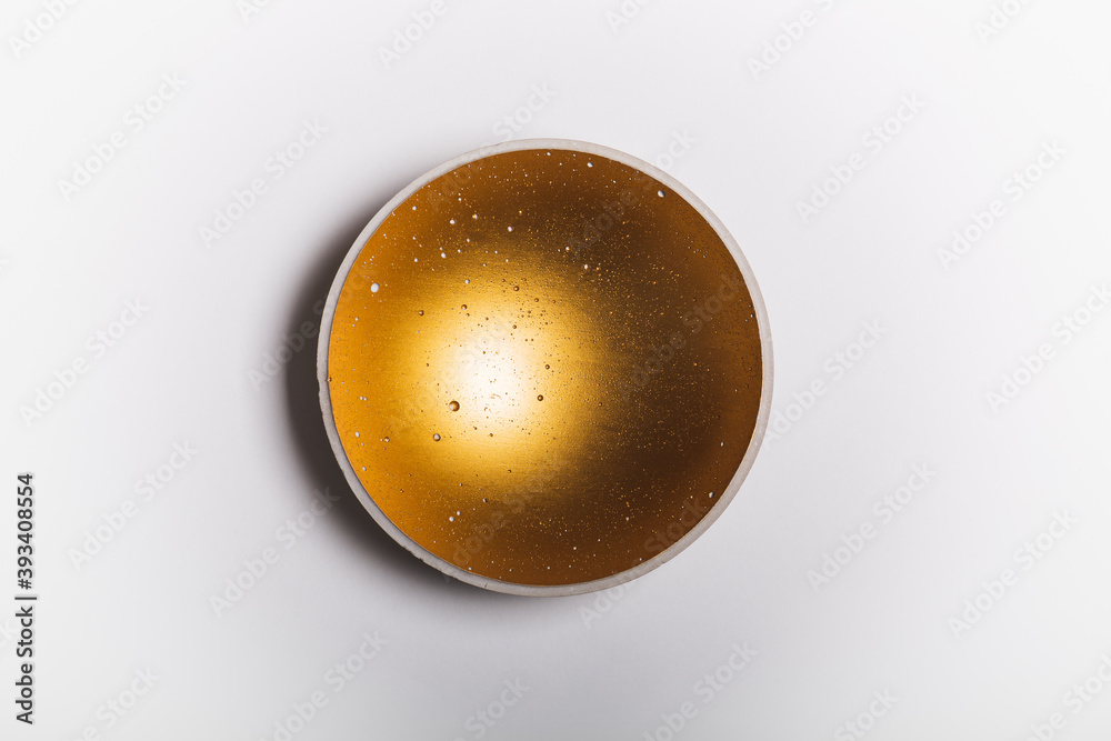 Hand made concrete bowl with fortuna golden finish on white background Hand made concrete bowl with fortuna golden finish on white background