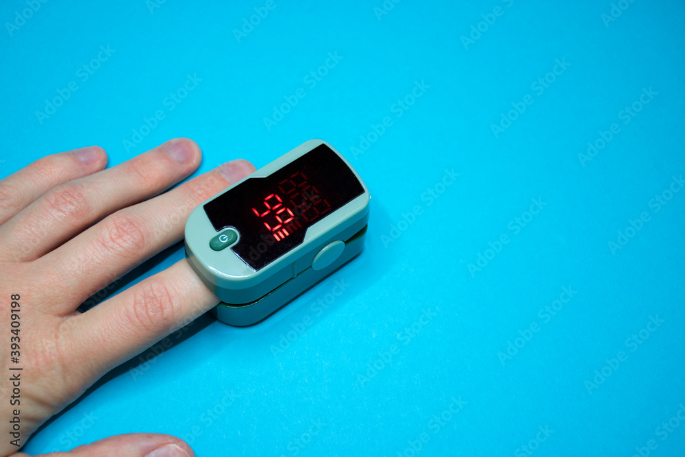 Pulse oximeter on finger for measuring pulse rate and blood oxygen saturation level to check