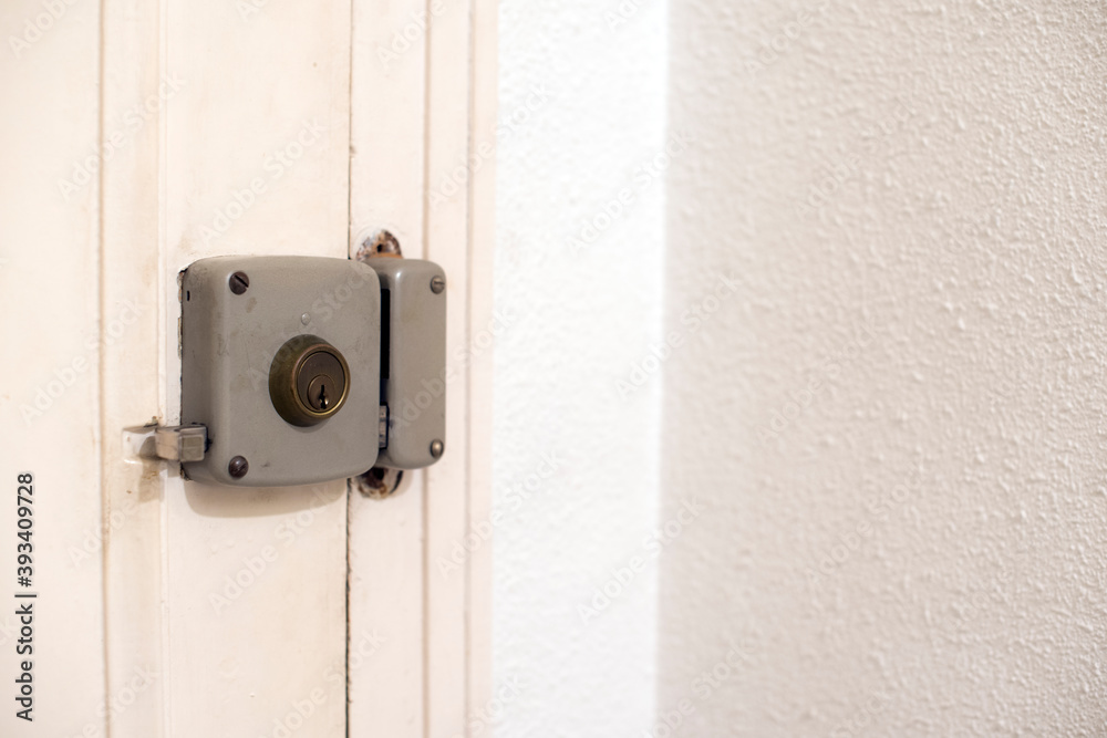 Una cerradura gris de una puerta blanca con una pared blanca Una cerradura gris de una puerta blanca con una pared blanca
