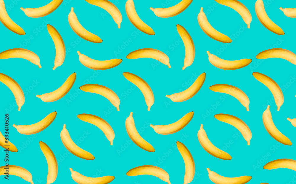 Pattern with whole bananas with a shadow on the turquoise surface as a decorative background. Pattern with whole bananas with a shadow on the turquoise surface as a decorative background.