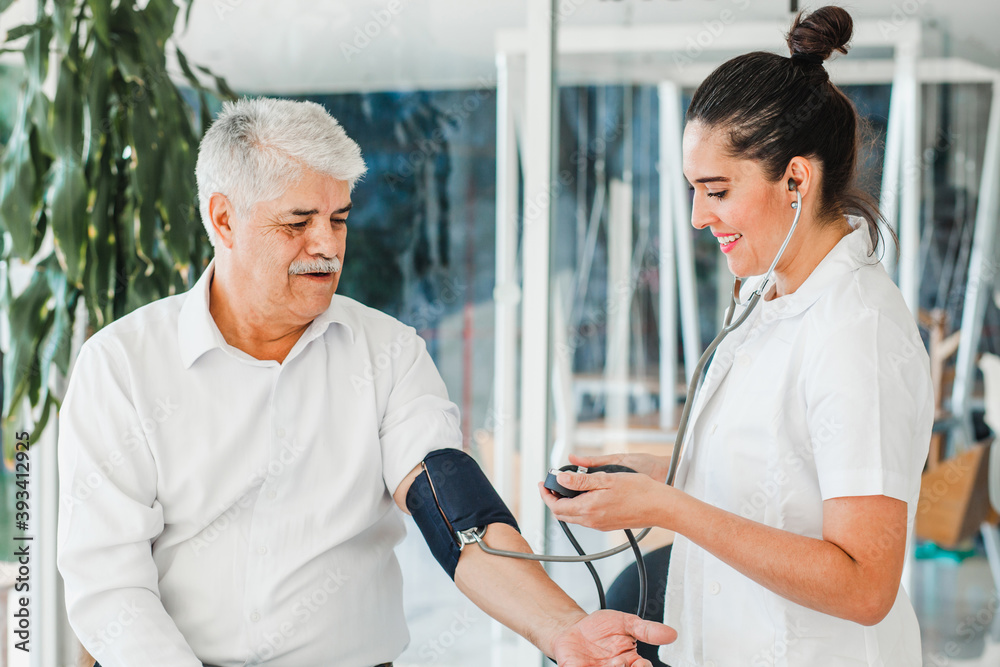 Obraz premium hispanic woman doctor examining senior patient in medical clinic in Mexico