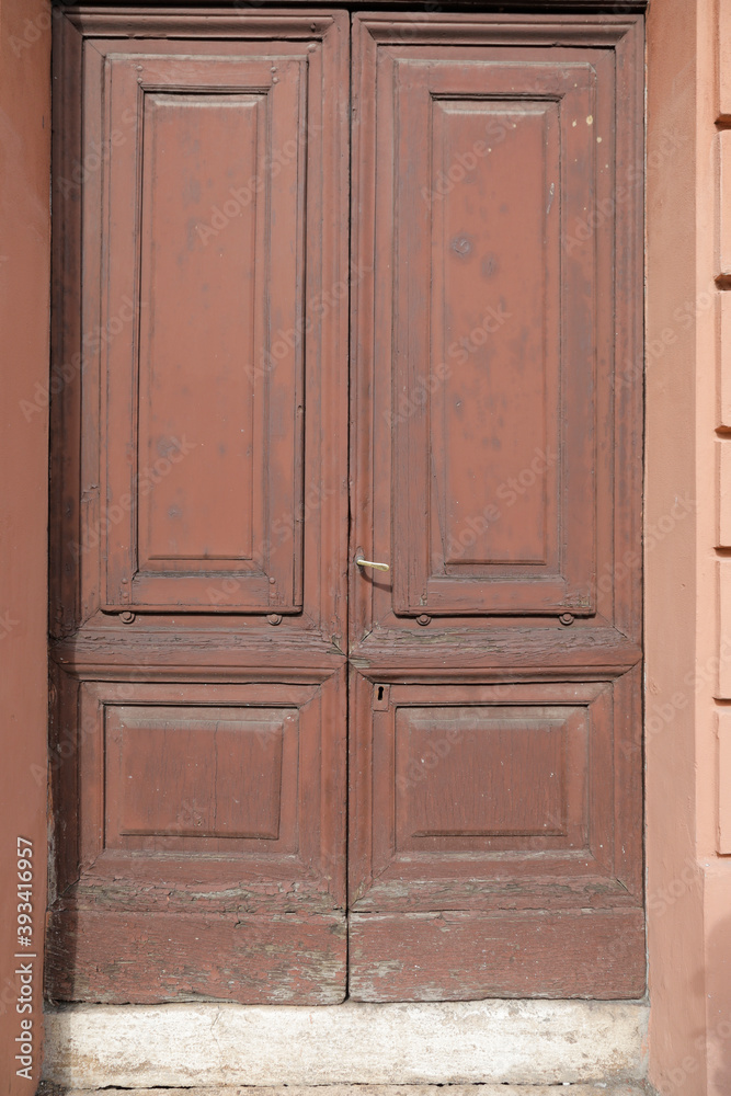 Red brown door with weathered frames, closed shutter with space for text, no person Red brown door with weathered frames, closed shutter with space for text, no person