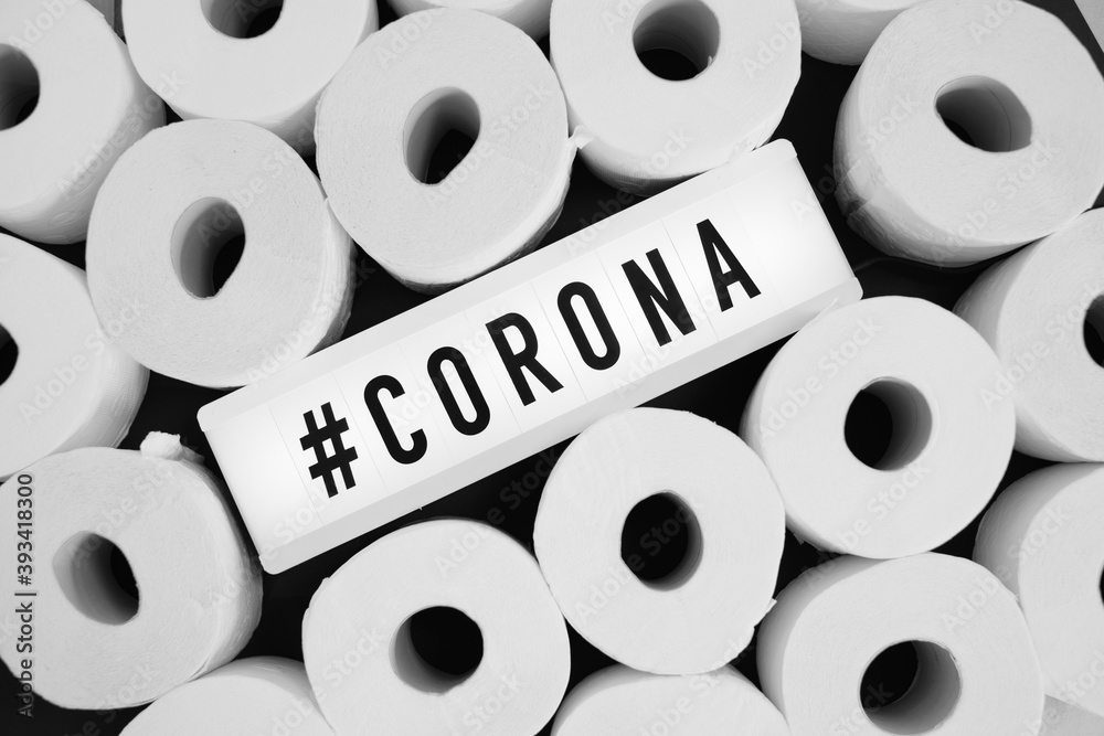 sign with the inscription #Corona can be found in the middle of many white toilet paper rolls sign with the inscription #Corona can be found in the middle of many white toilet paper rolls