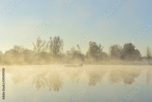 Fototapeta Naklejka Na Ścianę i Meble -  Romantic landscape in autumn, in the morning with rising haze over a lake and at sunrise