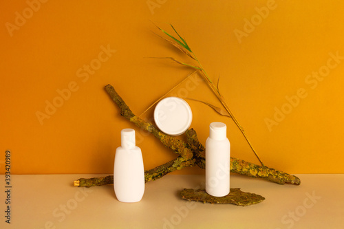 Set of natural organic eco cosmetic products in white plastic jar, dispenser bottle, tube on orange background. Skincare concept. Front view, mock up.