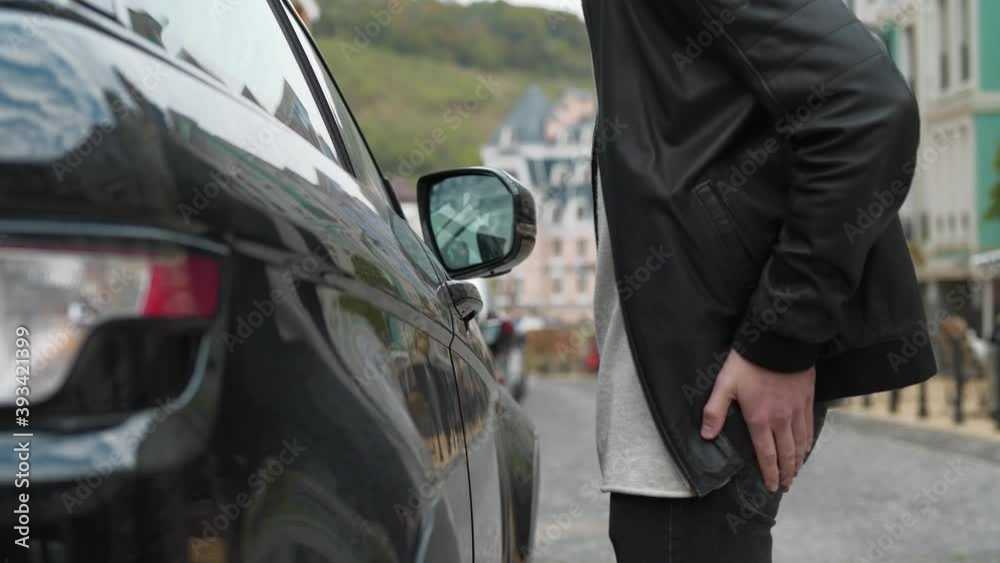 Man approaches a his car, pulls the door handle, realizes that he forgot the keys and leaves annoyed Man approaches a his car, pulls the door handle, realizes that he forgot the keys and leaves annoyed
