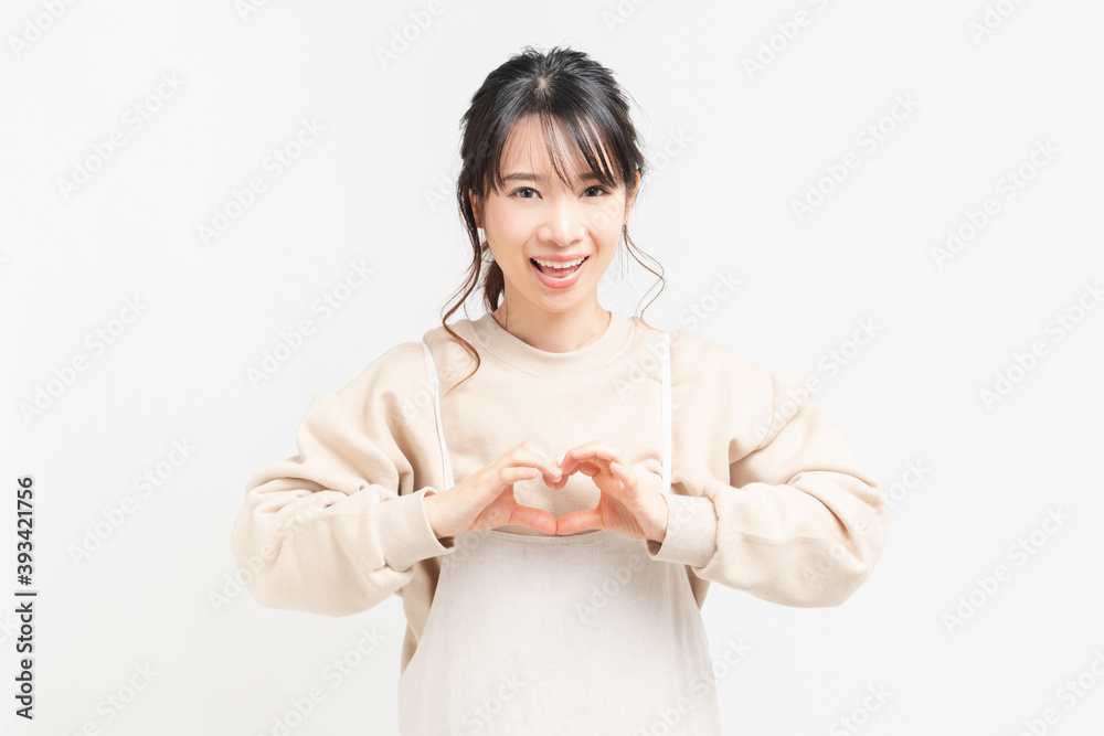 手でハートの形を作る若い女性