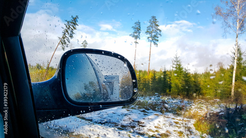 Car campin travel trip active vacation on sunny winter day, indoor view from car to front side window to outdoor back view mirror caravan trailer reflection. Car traveling and winter holidays concept. photo