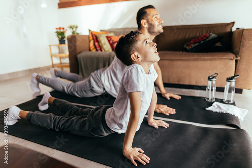 Young father and child son training and stretching at home