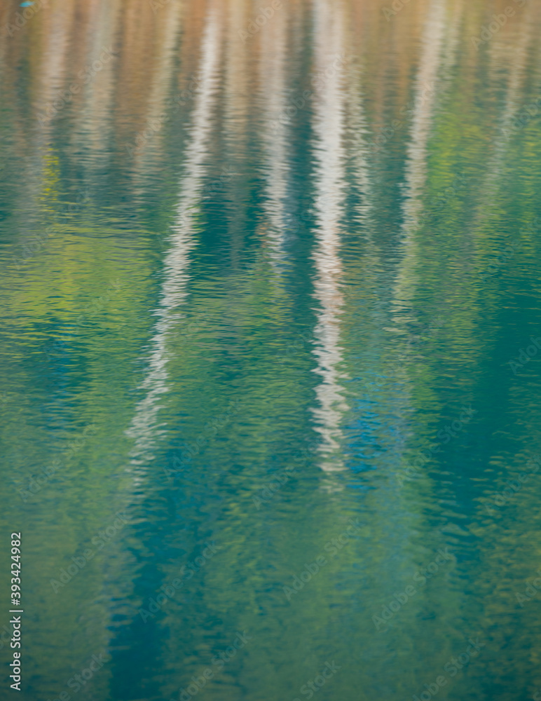 waters reflection showing birch trees and autumn forest artistic background in pastoral colours with ripples waters reflection showing birch trees and autumn forest artistic background in pastoral colours with ripples