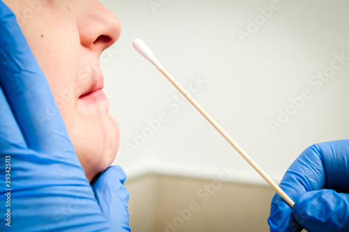 Doctor takes a cotton bud from patients nose to analyze samples for the COVID-19 test. Coronavirus test concept photo