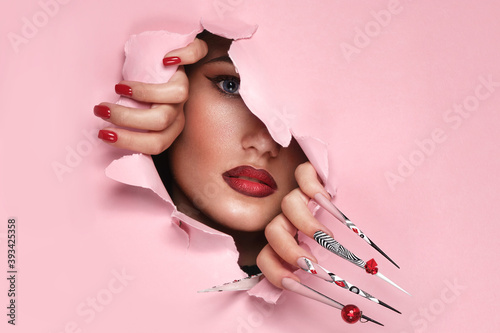 Portrait of a beautiful woman with art make up in glamorous style, creative long nails. Design manicure. Beauty face. photo