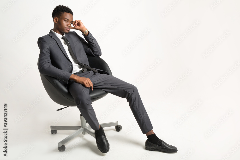 handsome young african man in suit on white background in armchair handsome young african man in suit on white background in armchair