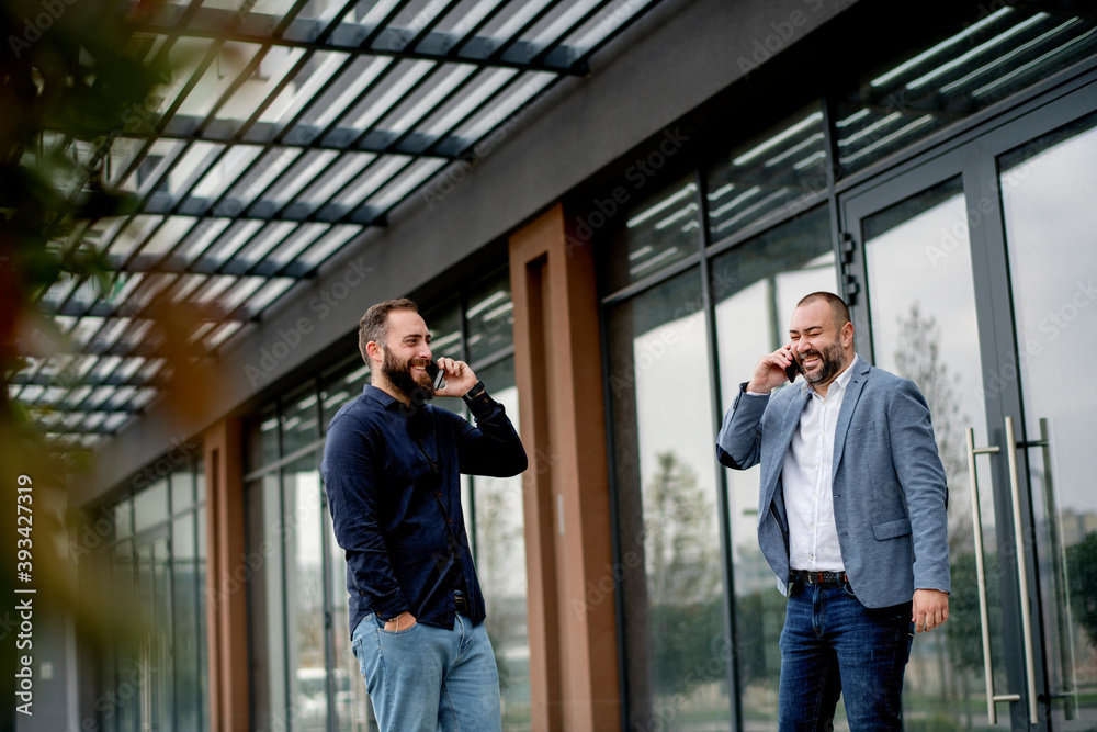 Two colleagues on coffee break in front of business building Two colleagues on coffee break in front of business building