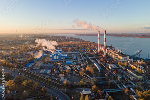 Aerial view of cityscape with industrial enterprises and emission of harmful smoke from the chimneys. Environmental pollution toxic industrial pipe