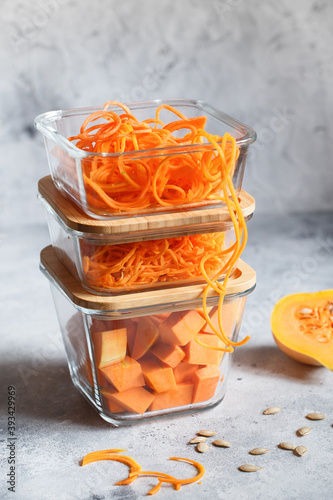 Glass boxes with fresh raw orange vegetables. Finaly shredded pumpkin and big pieces. Healthy Meal Prep, recipe preparation photos. Healthy vegan dishes in glass containers. Weight loss food concept photo