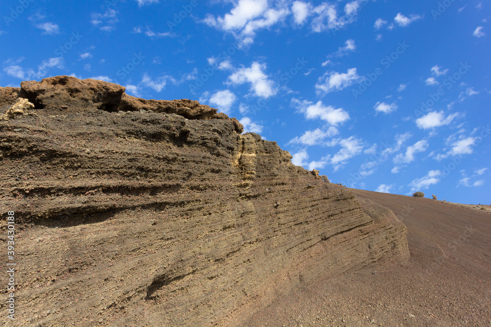 Volcanic geological formation on sunny day in Lanzarote. Parallel lines on eroded rocky wall in Canary Islands