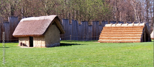 exterior of the archeopark, log construction with straw roofing, ancient Celtic buildings and palisades photo