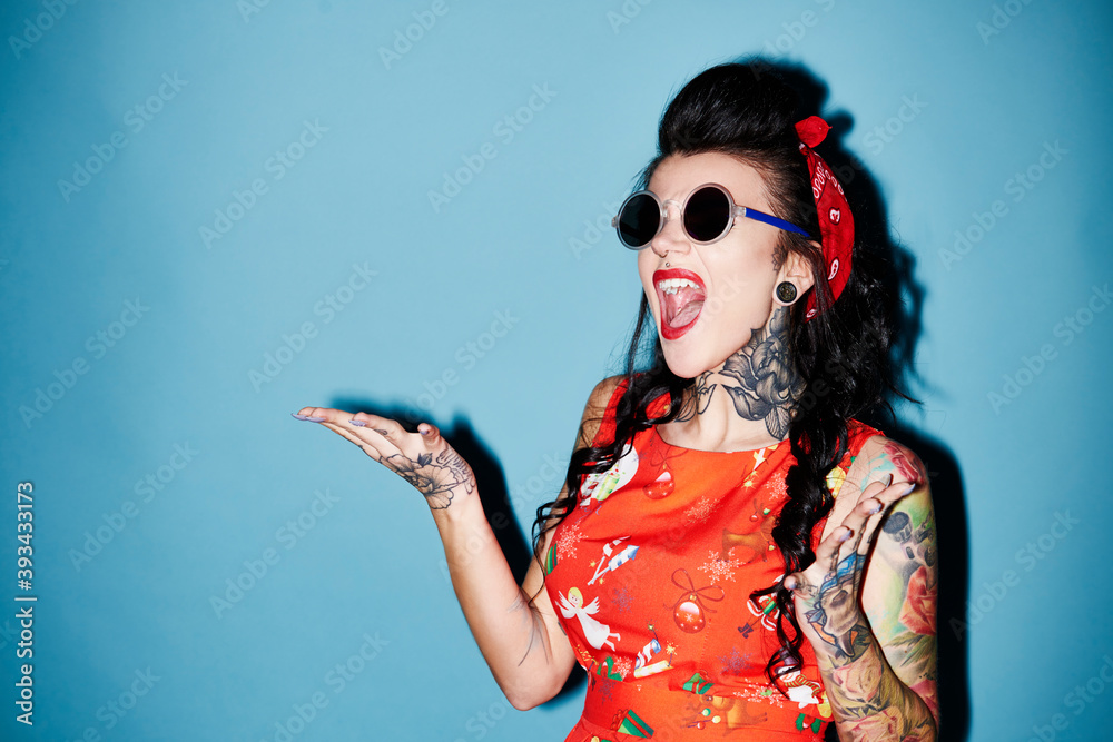 Portrait of tattooed woman against blue background Portrait of tattooed woman against blue background