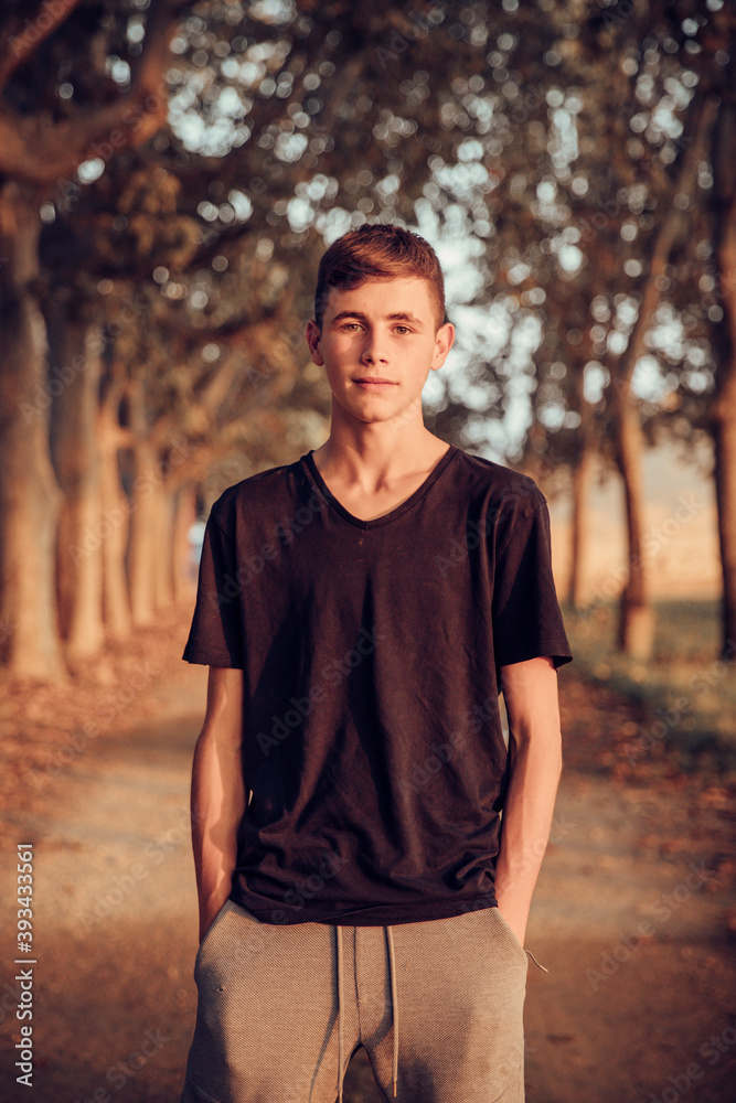 Teenage boy with hands in pockets standing on road Teenage boy with hands in pockets standing on road