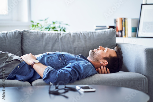 Relaxed man sleeping on sofa