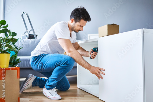 Man assembling a bookshelf in new apartment