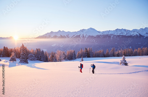 Austria, Tyrol, couple snowshoeing at sunrise photo