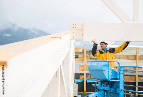 Austria, worker on hoist, positioning roof construction