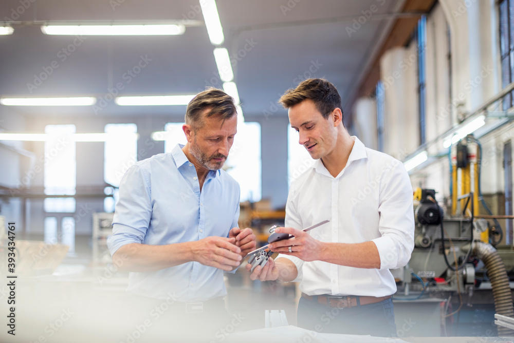 Two businessmen in factory discussing product Two businessmen in factory discussing product