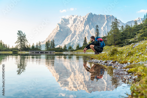 Austria, Tyrol, Hiker taking a break, crouching by the lake