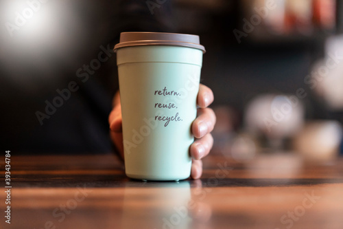 Hand holding deposit cup for Coffee to go, close-up