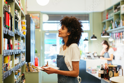 Woman with clipboard at shelf in a store photo