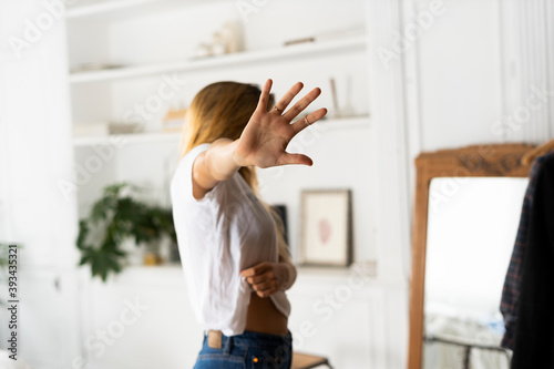 Abuse and violence against women, woman raising hand at home photo