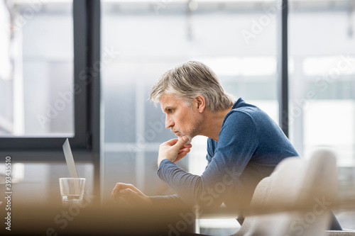 Mature businessman working in office, using laptop