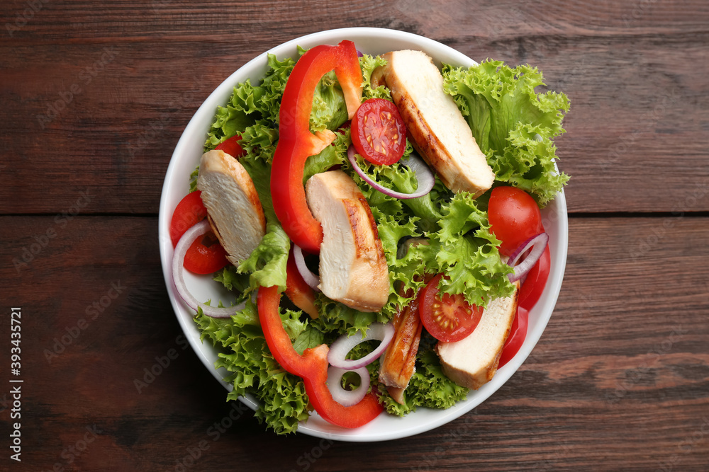 Delicious salad with chicken and vegetables on wooden table, top view Delicious salad with chicken and vegetables on wooden table, top view