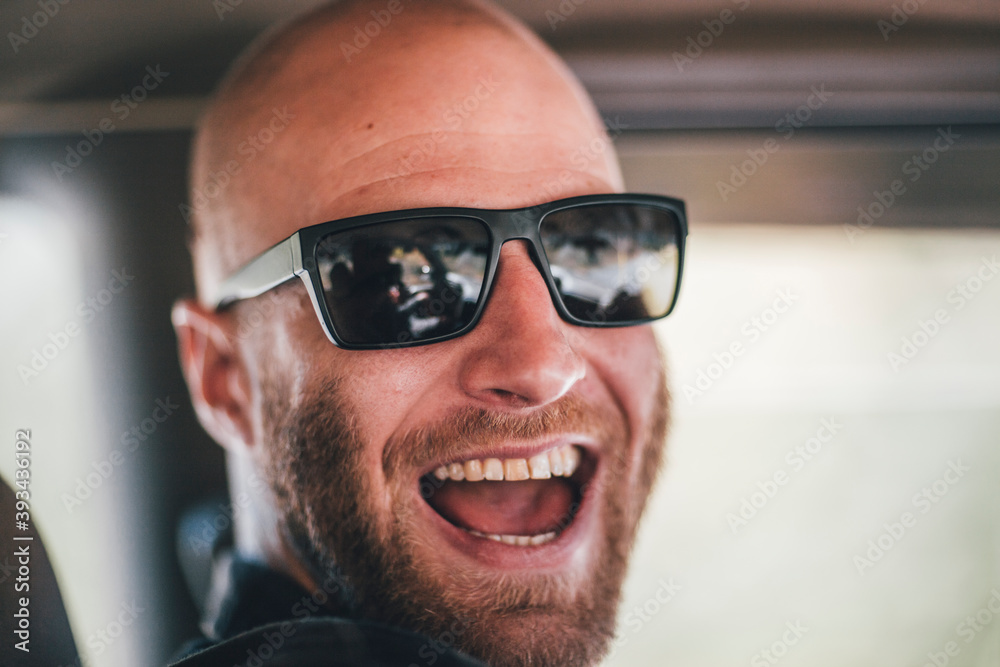Portrait of happy young man with sunglasses and beard on a road trip Portrait of happy young man with sunglasses and beard on a road trip